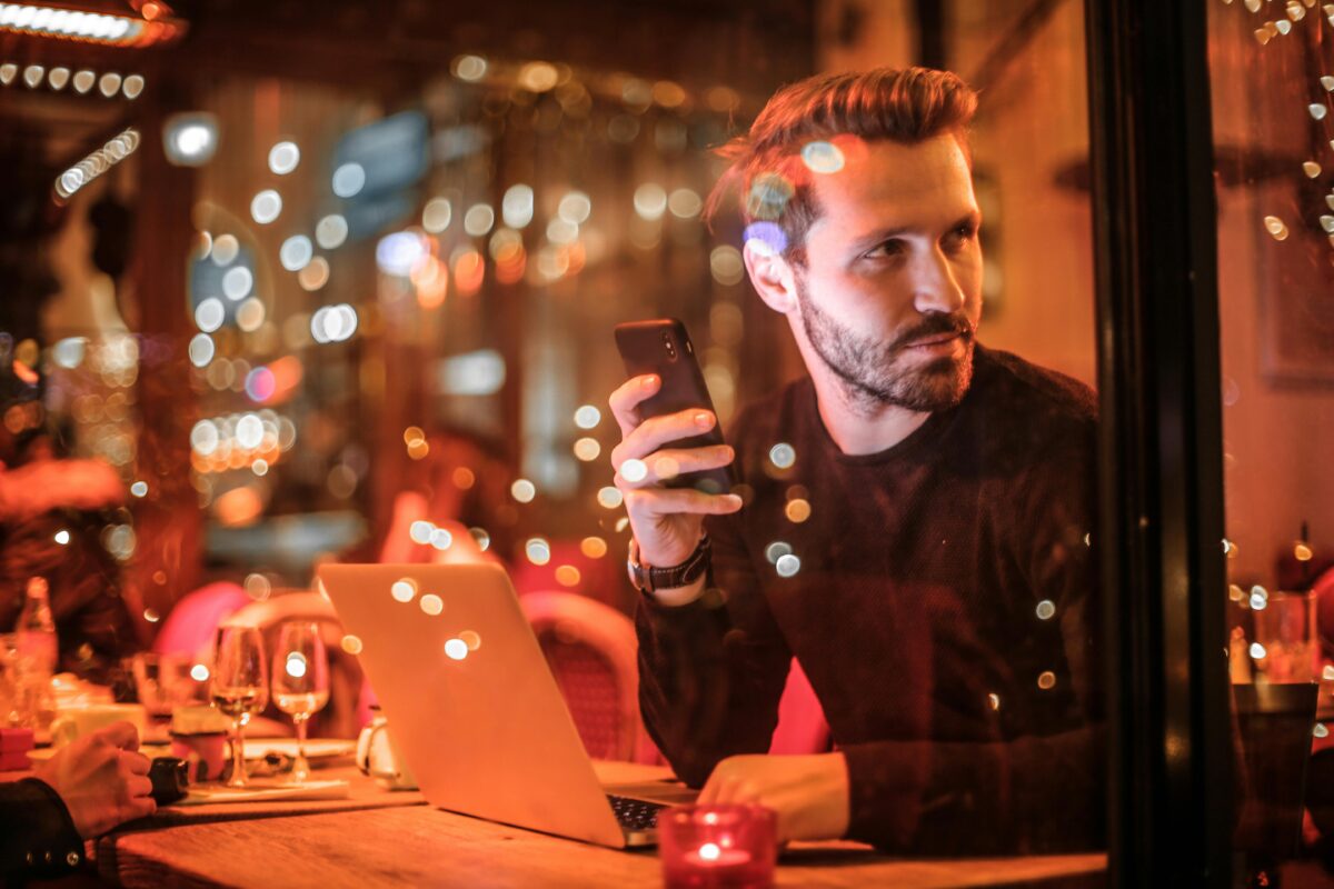 Man checking phone in a cafe at night